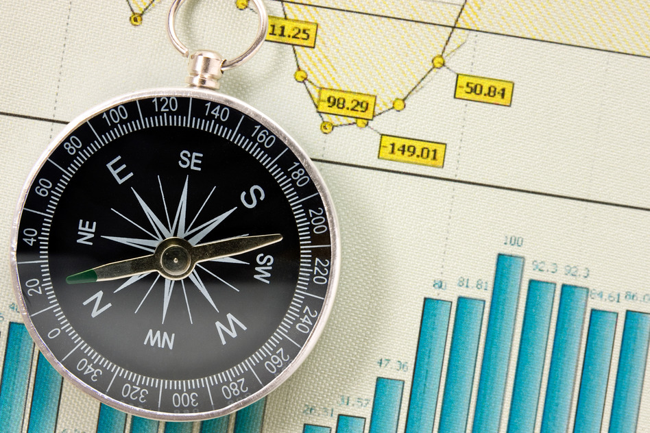 Economic growth charts and compass